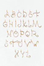 Lettre tissée en perles de culture
